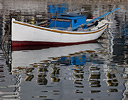Fishing boat in harbor Hora in reflection, Mykonos Greek Isles